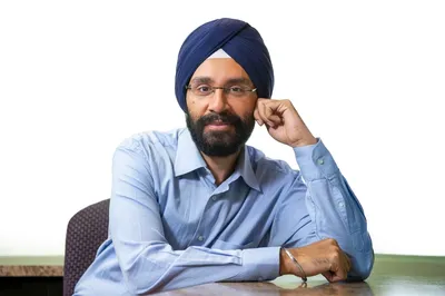 A man with a turban sitting at a table.