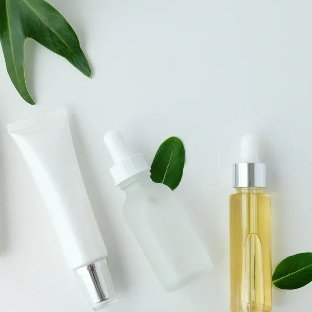 A white table topped with bottles of lotion and cream.